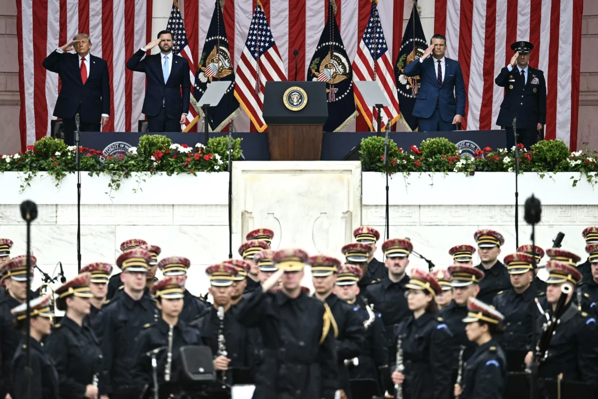 (L–R) President Donald Trump, Vice President JD Vance, Secretary of War Pete Hegseth, and Chairman of the Joint Chiefs of Staff General Dan Caine salute during the National Memorial Day Observance at the Memorial Amphitheatre in Arlington National Cemetery in Arlington, Va., on May 25, 2026. (Kent Nishimura/AFP via Getty Images)
