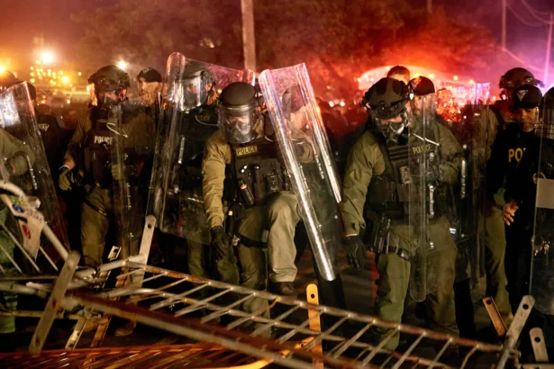 Police pass over a barricade as they clash with protesters near the Delaney Hall detention center during a protest against the transfer of detainees and federal immigration policies in Newark, N.J., on May 30, 2026. (Andres Kudacki/AP Photo)
