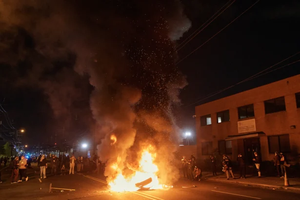 People watch a burning barricade near the Delaney Hall detention center during a protest against the transfer of detainees and federal immigration policies in Newark, N.J., on May 30, 2026. (Andres Kudacki/AP Photo)