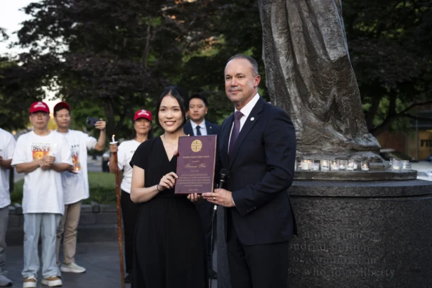 Frances Hui, policy and advocacy coordinator of the Committee for Freedom in Hong Kong Foundation, receives a dissident human rights award during the Tiananmen Square massacre candlelight vigil held at the Victims of Communism Memorial in Washington on June 4, 2026. (Madalina Kilroy/The Epoch Times)