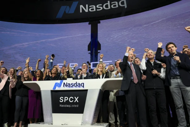 Gwynne Shotwell (at podium, center R), SpaceX President and Chief Operating Officer, is joined by SpaceX executives and employees as they ring the opening bell at the Nasdaq MarketSite to celebrate the launch of SpaceX's initial public offering (IPO) in New York City on June 12, 2026. (Timothy A. Clary/AFP via Getty Images)