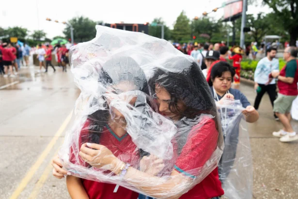 Portugal fans share a poncho to protect themselves from the rain as they wait to enter Houston Stadium before a FIFA World Cup match between Portugal and Congo in Houston, Texas, on June 17, 2026. (Jason Fochtman/Houston Chronicle via AP)