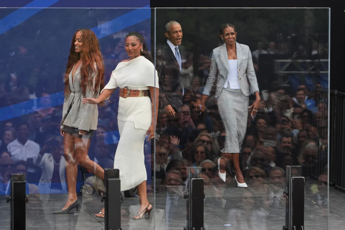 Former President Barack Obama (back center) and former first lady Michelle Obama (R) arrive on stage with their daughters, Malia and Sasha Obama (L), during the dedication ceremony for the Obama Presidential Center in Chicago on June 18, 2026. (Jeff Roberson/AP Photo)