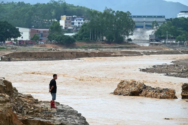 A man looks at water flowing from the collapsed Liulan reservoir in Liulan village of Hengzhou city in China's southwest Guangxi region, on July 8, 2026. (Greg Baker/AFP via Getty Images)