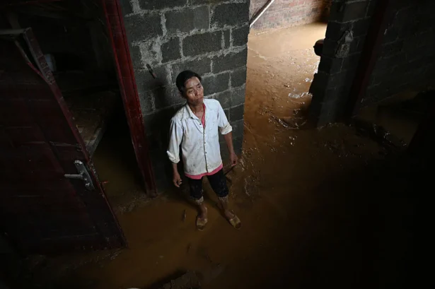 A resident looks up at damage to his house, which was flooded when the Liulan reservoir collapsed on July 6, in Liulan village in Hengzhou city in China's southwest Guangxi region, on July 8, 2026. (Greg Baker/AFP via Getty Images)