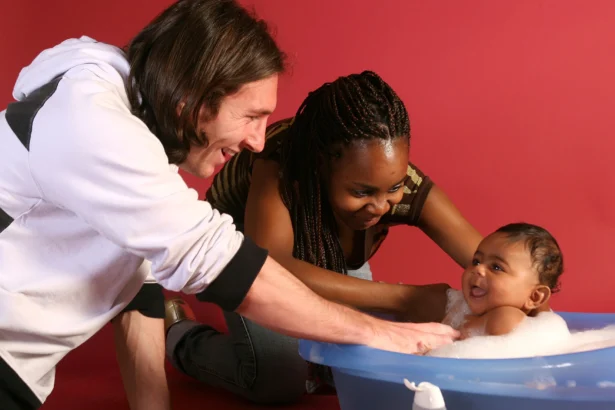 20-year-old soccer star Lionel Messi helps to bathe Lamine Yamal, who was merely six months old at the time with Yamal's mother Sheila Ebana during a photo session in the dressing room of the Camp Nou stadium in Barcelona, Spain, in September 2007. (Joan Monfort/AP Photo)