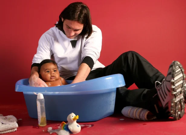 20-year-old soccer star Lionel Messi helps to bathe Lamine Yamal, who was merely six months old at the time, during a photo session in the dressing room of the Camp Nou stadium in Barcelona, Spain, in September 2007. (Joan Monfort/AP Photo)