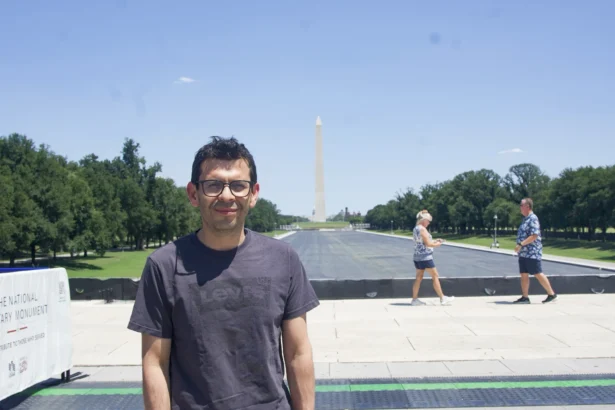 Andres Mancpecce, from Colombia, stands near thousands of Falun Gong practitioners who were lining up for a parade at the Lincoln Memorial in Washington, on July 23, 2026. (Karina Li for The Epoch Times)