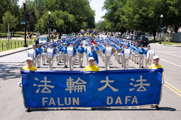 Falun Dafa practitioners take part in a march calling for the end of the Chinese Communist Party’s 27 years of persecution of Falun Gong in China, in Washington on July 23, 2026. (Larry Dye/The Epoch Times)