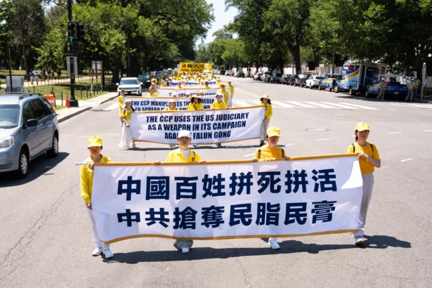 Falun Dafa practitioners take part in a march calling for the end of the Chinese Communist Party’s 27 years of persecution of Falun Gong in China, in Washington on July 23, 2026. (Larry Dye/The Epoch Times)