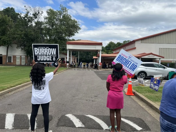 Campaigners stand in a Memphis-area parking lot touting their candidate as residents line up to submit their early vote on Aug. 1, 2026. (Jacki Thrapp/The Epoch Times)