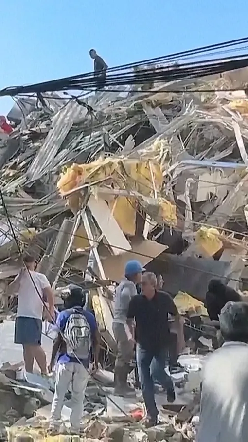 People Flee Debris Falling From Buildings During Colombia Quake