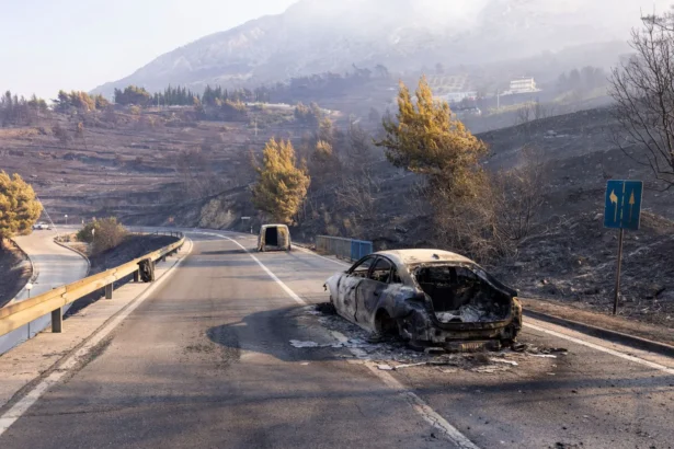 This photograph shows burnt cars on a road after a wildfire near the town of Omis, some 30 kilometers south of Split, on Aug. 14, 2026. (Miroslav Lelas/AFP via Getty Images)