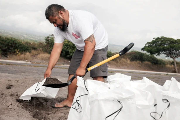 Casey Delaries makes a sandbag in preparation for Tropical Storm Lala in Kailua-Kona, Hawaii, on Aug. 14, 2026. (Stephen Lam/San Francisco Chronicle via AP)