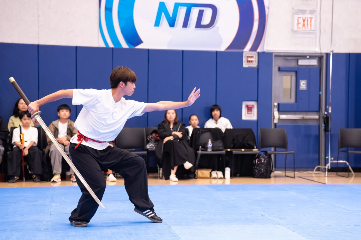 Liang Songqi of Taiwan performs with a miaodao in the junior weapons semifinal in Manhattan on Aug. 14, 2026. (Larry Dye/The Epoch Times)