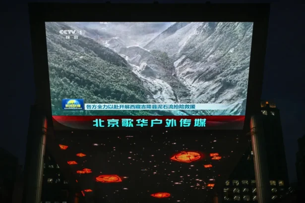 A giant screen outside a shopping mall in Beijing shows a news report featuring an image of a landslide in Gyirong County, in China’s western Tibet region near the border with Nepal on Aug. 27, 2026. (Greg Baker/AFP via Getty Images)
