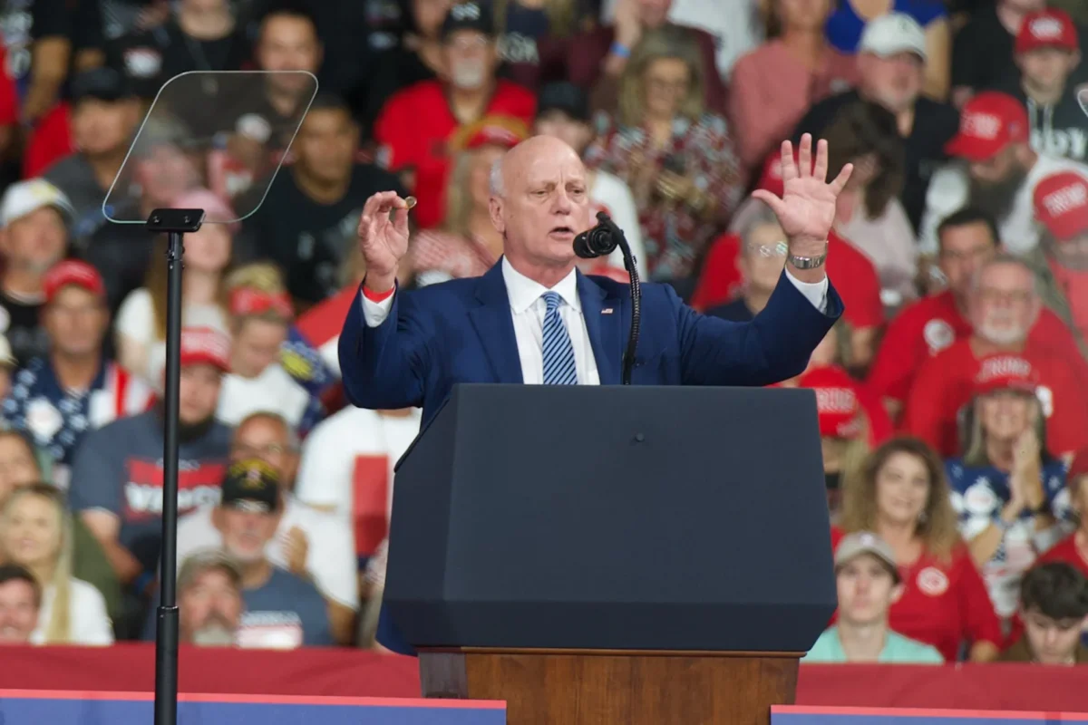 Treasurer Brandon Beach displays a new Trump dollar coin during a rally at the Guardian Centers in Perry, Ga., on Oct. 24, 2026. (Travis Gillmore/The Epoch Times)