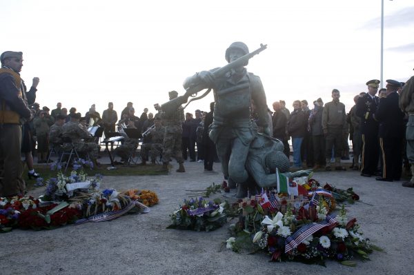 Floral tributes are placed at the National Guard Monument Memorial as members of the USAREUR band plays in the background near Omaha Beach, in Normandy, France on June 6, 2019. (Thibault Camus/Photo/AP)