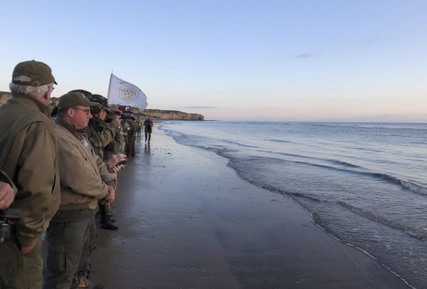 Reenactors stand at the shore of Omaha Beach at sunrise as part of events to mark the 75th anniversary of D-Day on Omaha Beach in Vierville-sur-Mer, Normandy, France on June 6, 2019. (Cedric Lecoz via AP)
