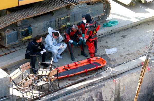 Rescuers rest on a huge floating crane under the Margit bridge, where the Hableany sightseeing boat sank after colliding with a much larger river cruise ship in Budapest, Hungary, on June 11, 2019. (Darko Bandic/AP Photo)