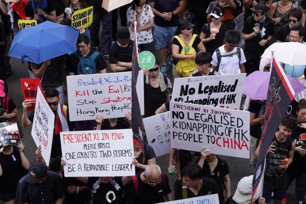 Protesters hold up different signs while participating in a march in Hong Kong on July 1, 2019. (Yu Gang/The Epoch Times)