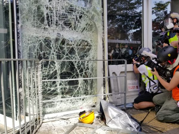 One of the glass walls is shattered at the Legislative Council after a group of protesters smashed a metal car against it on July 1, 2019. (Song Bilong/The Epoch Times)