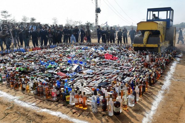 Pakistani custom officials look on as a steamroller smash bottles of alcohol at the Wagah border between Pakistan and India on January 26, 2019, to mark the International Custom day. (Arif AliI/AFP/Getty Images)
