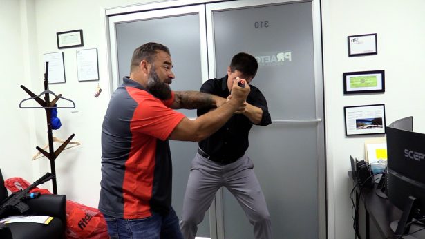 Kevin Holman demonstrates how to gain control of a smaller weapon like a handgun by grabbing it with both hands and rotating it back towards the shooter's ear in Walnut Creek, California, on Aug. 6, 2019. (Ilene Eng/NTD)