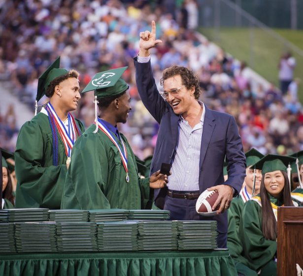Longview Lobos Kamden Perry (L) and Jephaniah Lister present actor and 1988 Longview High School graduate Matthew McConaughey with an autographed football and his own state championship ring at the school's graduation ceremony in Longview, Texas, on May 17, 2019. (Les Hassell/The News-Journal via AP)