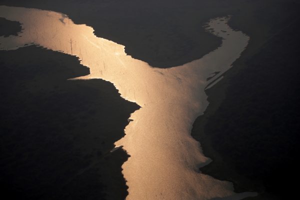 Sunlight is seen over the lake of Samuel Hydroelectric Dam in an area of the Amazon rainforest near Porto Velho, Rondonia State, Brazil, on Aug. 21, 2019. (Ueslei Marcelino/Reuters)