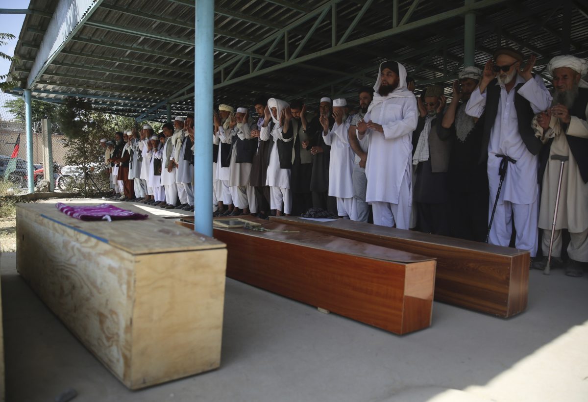 Afghans pray near the coffins of victims of the Dubai City wedding hall bombing during a mass funeral in Kabul, Afghanistan, on Aug. 18, 2019 (Rafiq Maqbool/AP Photo)