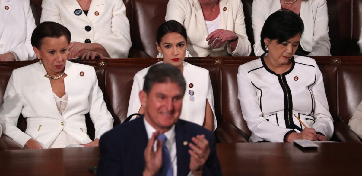 Democratic women of the House of Representatives, including Rep. Alexandria Ocasio-Cortez (D-N.Y.) (C), remain seated as Sen. Joe Manchin (D-W.Va.) stands and applauds during President Donald Trump’s State of the Union address in Washington on Feb. 5, 2019. (Jonathan Ernst/Reuters)