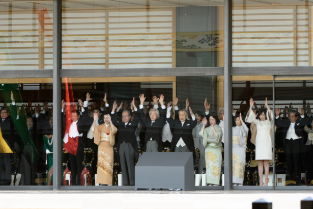 Japanese dignitaries and government representatives raise their arms giving a banzai cheer during the enthronement ceremony of Japan