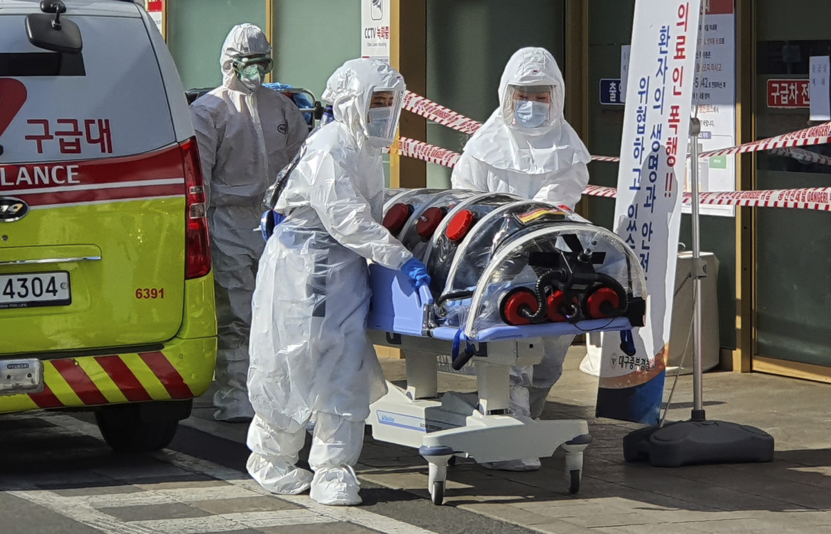 Medial workers wearing protective gear move a patient suspected of contracting the new coronavirus from an ambulance to the Kyungpook National University Hospital in Daegu, South Korea, on Feb. 19, 2020. (Kim Jong-un/Yonhap via AP)