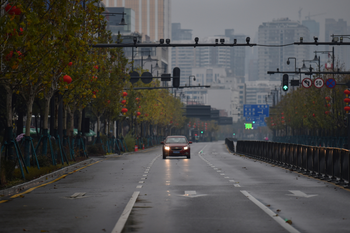 A lone car drives down a deserted street in Wuhan, China, on Jan. 26, 2020. (Hector Retamal/AFP via Getty Images)