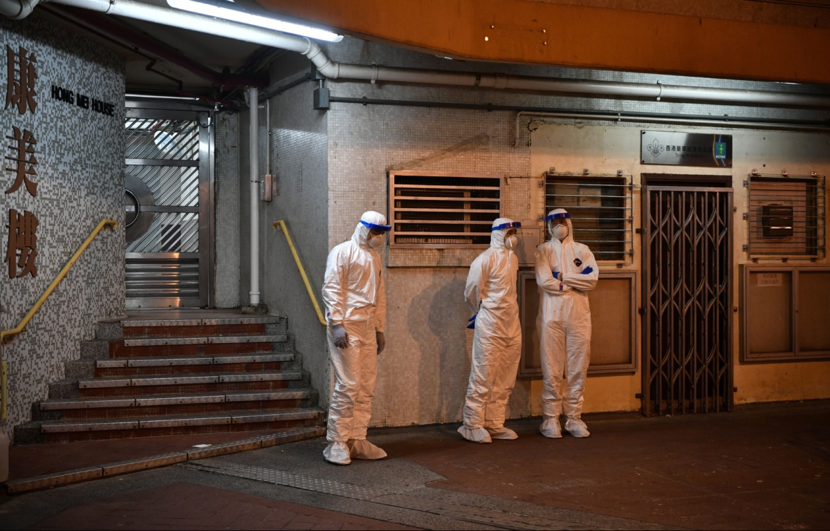 Medical personnel stand outside a block in the ground of a residential estate, in Hong Kong, early on Feb. 11, 2020, after two people in the block were confirmed to have contracted the coronavirus according to local newspaper reports. (Anthony Wallace/AFP via Getty Images)