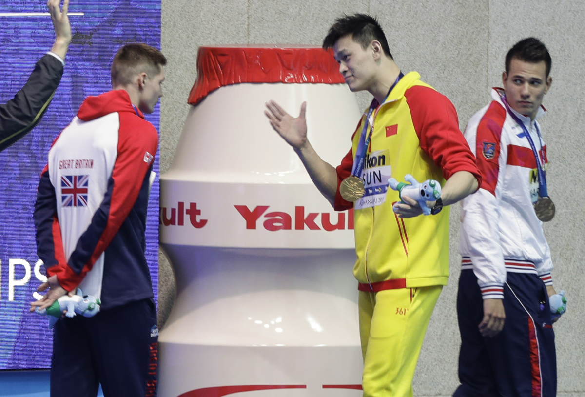 Gold medalist China's Sun Yang, center, gestures to Britain's bronze medalists Duncan Scott, left, following the medal ceremony in the men's 200m freestyle final at the World Swimming Championships in Gwangju, South Korea, on July 23, 2019. (Mark Schiefelbein/AP Photo)