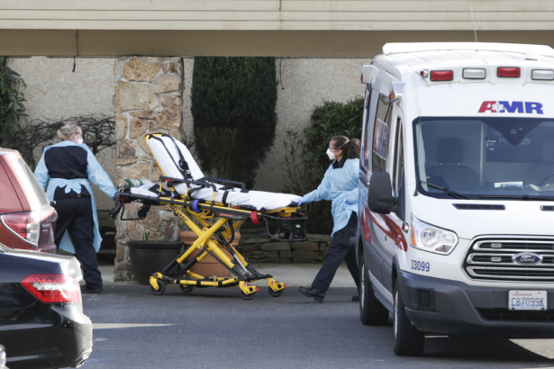 A stretcher is moved from an AMR ambulance to the Life Care Center of Kirkland where one associate and one resident were diagnosed with the novel coronavirus (COVID-19) on Feb. 29, 2020. (Jason Redmond/AFP via Getty Images)