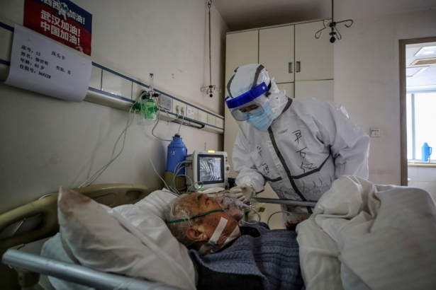 A medical staff member speaks with a patient infected by COVID-19 at Red Cross Hospital in Wuhan, China, on March 10, 2020. (STR/AFP via Getty Images)