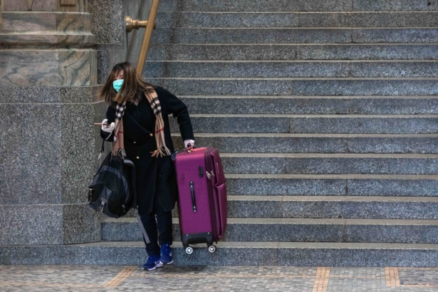 A woman, wearing a face mask, pulls a trolley at Milan's Central Station in Milan, Italy, on March 8, 2020. (Emanuele Cremaschi/Getty Images)