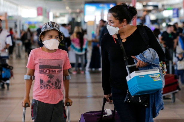 Passengers walk with protective masks at the Arturo Merino Benitez International Airport, in Santiago, Chile, on Mar. 3, 2020. (Javier Torres/AFP via Getty Images)