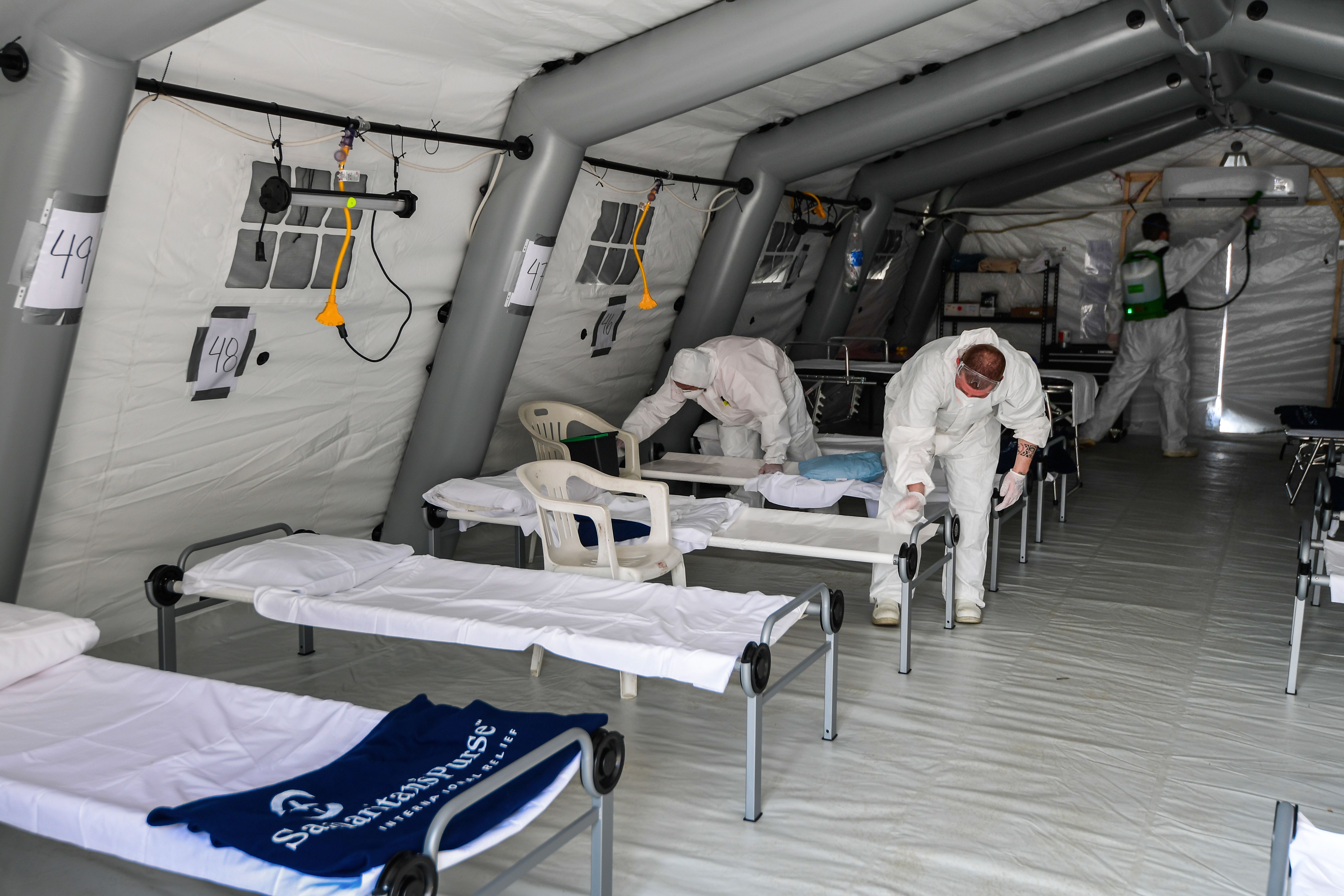 Workers disinfect a tent in a field hospital for CCP virus patients in Cremona, Italy, on March 20, 2020. (Miguel Medina/AFP via Getty Images)