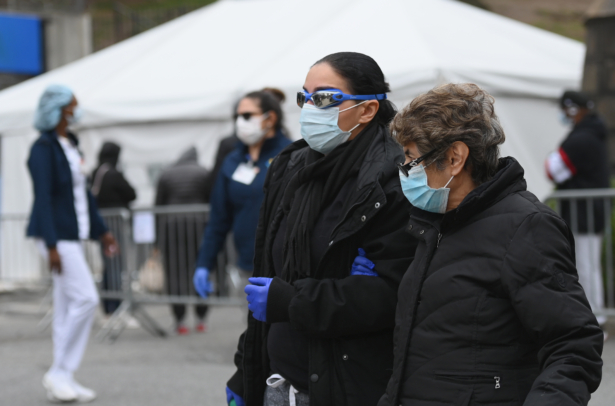 People wearing masks and goggles pass