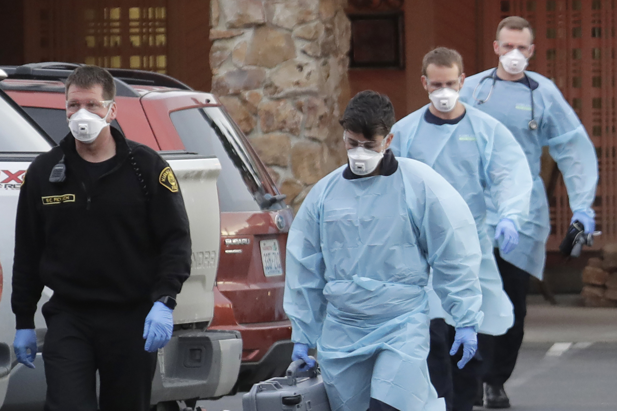 Kirkland Fire and Rescue ambulance workers walk back to a vehicle after a patient was loaded into an ambulance at the Life Care Center in Kirkland, Washington state, on March 10, 2020. (Ted S. Warren/AP Photo)