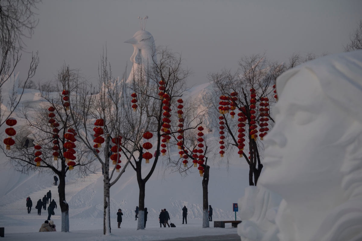 Tourists walk past ice sculptures 