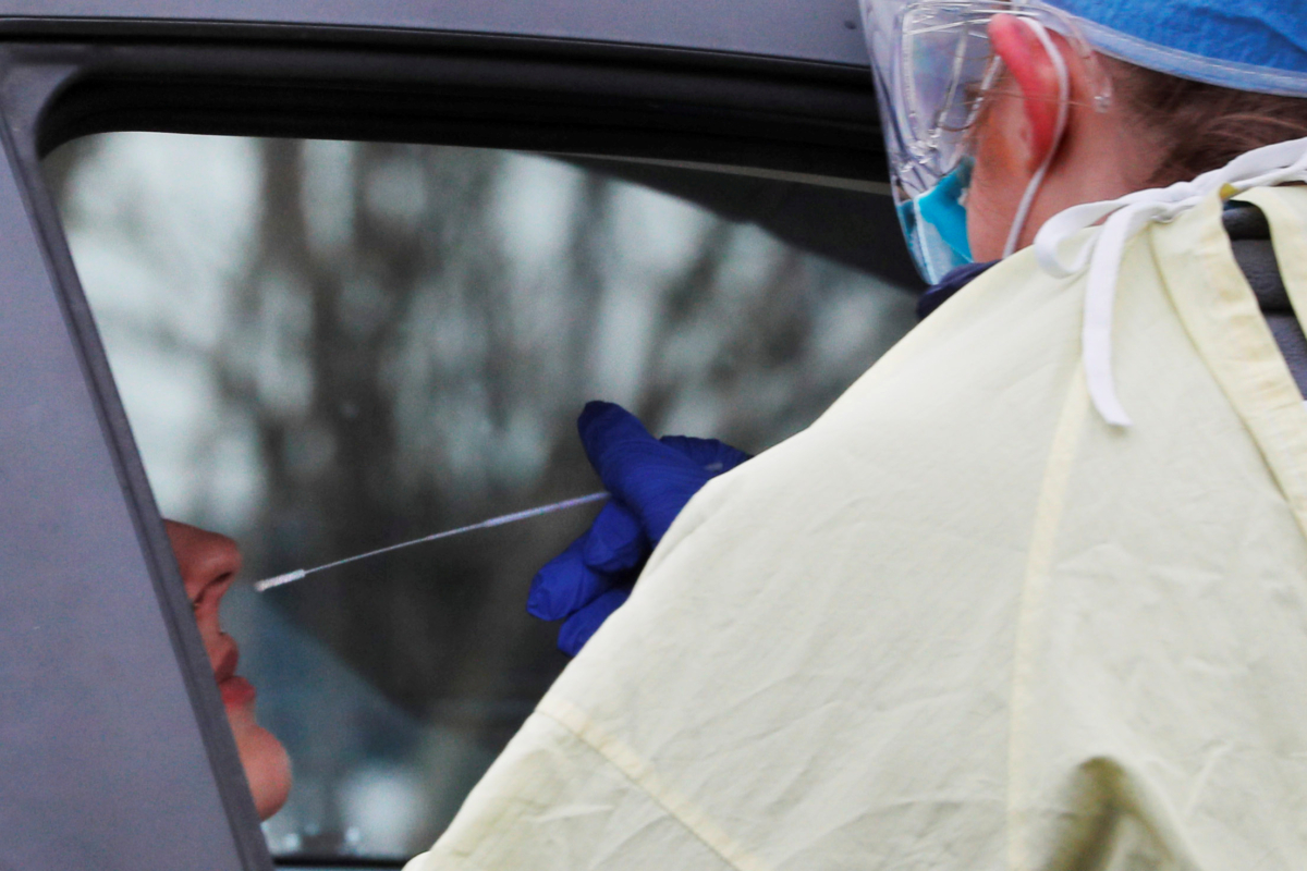 A medical technician takes a sample to test for COVID-19 at a drive-through testing site in Medford, Massachusetts, on April 4, 2020. (Brian Snyder/Reuters)