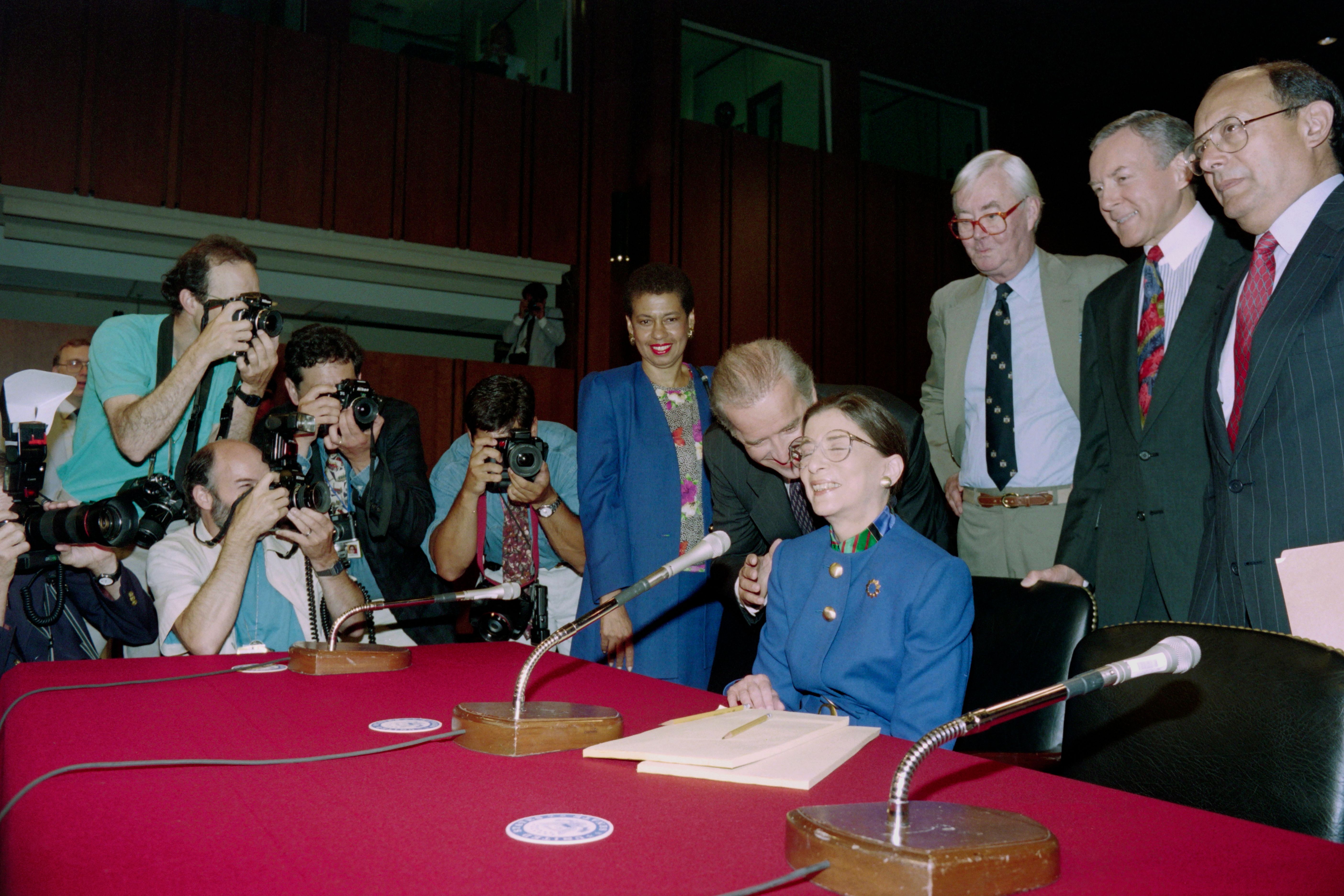 Sen. Joe Biden (D-Del.), chairman of the Senate Judiciary Committee, whispers to judge Ruth Bader Ginsburg shortly before his committee began Ginsburg's confirmation hearing in Washington for the position of associate justice of the Supreme Court, on July 20, 1993. (Jennifer Law/AFP via Getty Images)