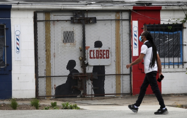 A pedestrian walks past a closed barber shop in Ward 7 as the CCP virus outbreak continues in Washington on May 8, 2020. (Leah Millis/Reuters)