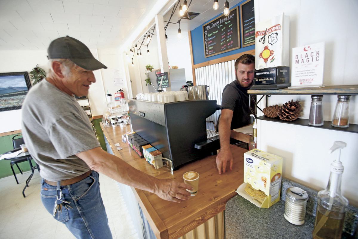 Jonathan Archibald, the owner of Mt Taylor coffee, sells a cup of coffee to Paul Jackson in Grants, N.M., on April 27, 2020. (Luis Sánchez Saturno/Santa Fe New Mexican via AP)