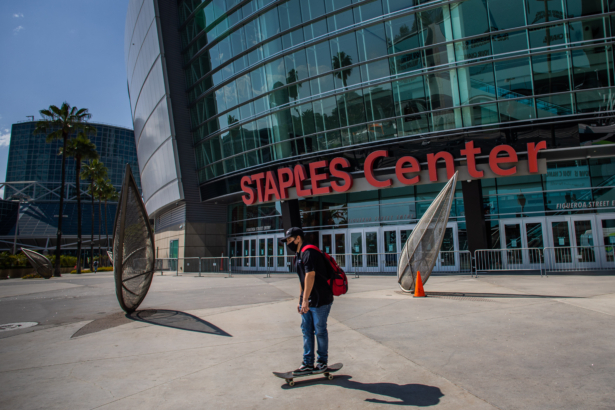 A man wearing a mask skates in front of the Staples Center in downtown Los Angeles, Calif., on May 9, 2020. (Apu Gomes/AFP via Getty Images)